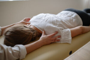A woman receiving soft tissue therapy from a chiropractor.